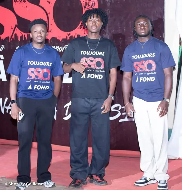 Trois membres de la team en t-shirts SSO devant le mur du photocall