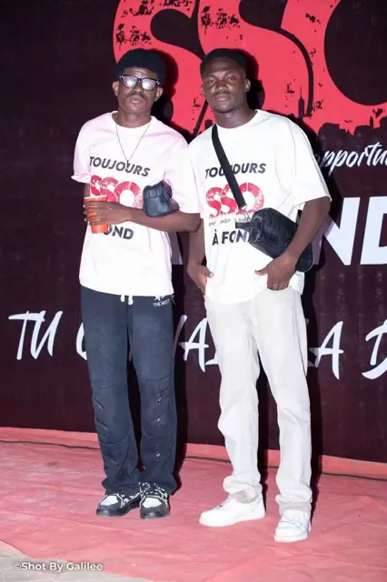 Deux jeunes hommes en t-shirts SSO rose et noir au photocall