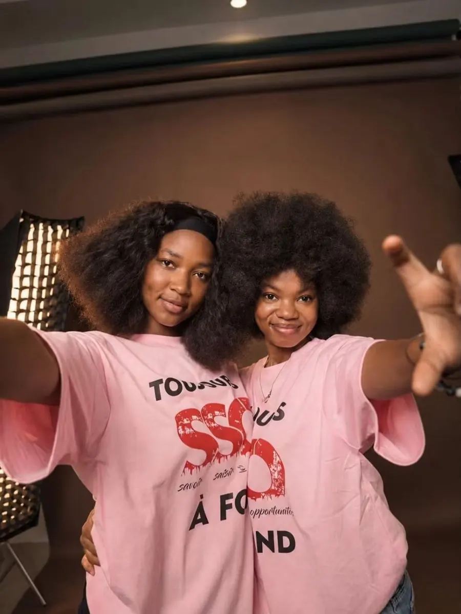 Deux amies en t-shirts roses SSO, bras tendus vers la caméra