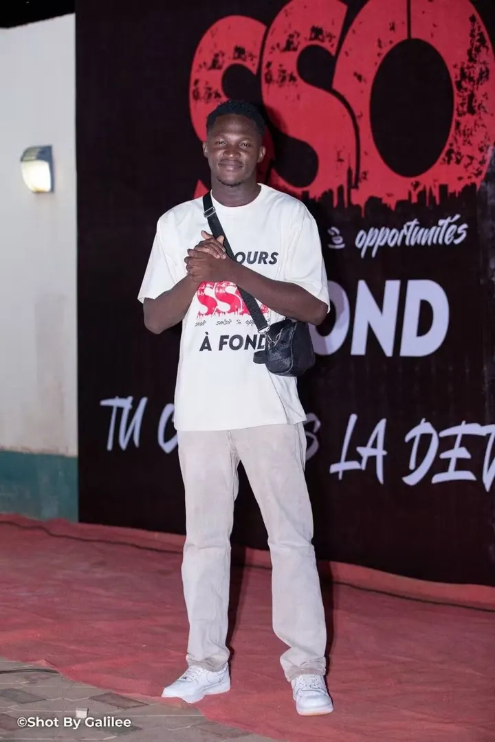 Odilon, membre de la team SSO, devant le mur SSO en t-shirt blanc